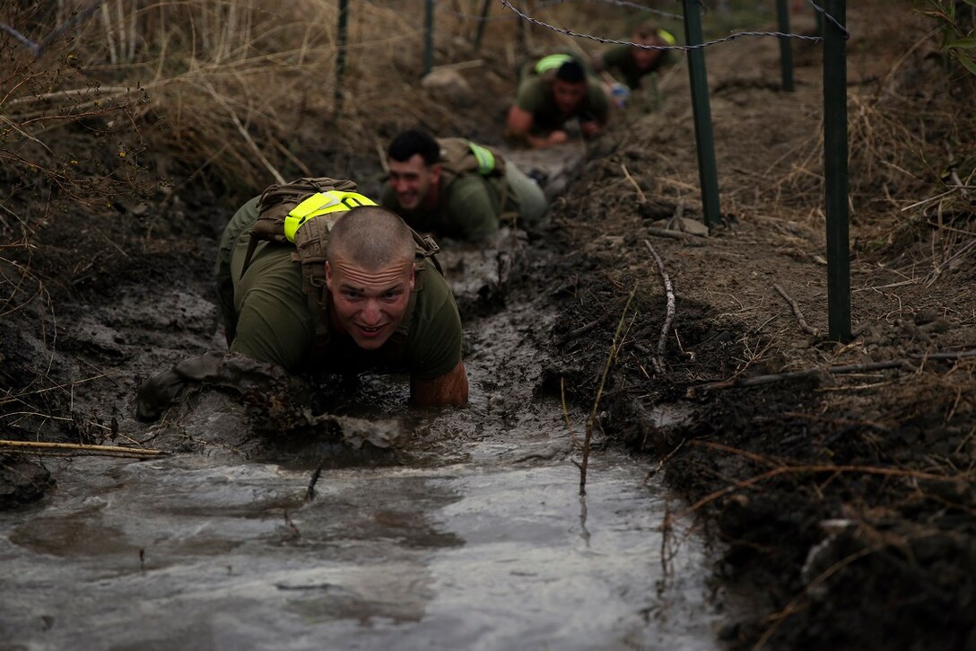 Marines assigned to Company K, 3rd Battalion, 5th Marine Regiment, 1st Marine Division, low-crawl through a trench during the Dark Horse Ajax Challenge aboard Marine Corps Base Camp Pendleton, Calif., Aug. 20, 2015. The eight-mile course tested the Marines’ and Sailors’ endurance and leadership skills with trials spread across the San Mateo area. (U.S. Marine Corps photo by Cpl. Will Perkins)