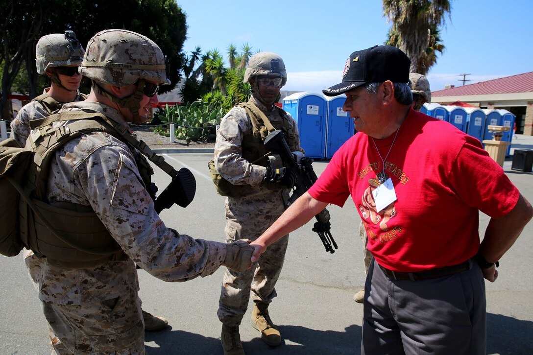 Marines with 3rd Battalion, 5th Marines, 1st Marine Division, give thanks to a Vietnam veteran that is a member of the 1st Mar. Div. Association during the 68th annual 1st Mar. Div. Association reunion, aboard Marine Corps base Camp Pendleton, Calif., Aug. 20, 2015. During the reunion, veterans visited their old stomping grounds and reminisced about their days serving in the division, while also observing the capabilities of today’s Marines.  (U.S. Marine Corps photo by Cpl. Demetrius Morgan/RELEASED)