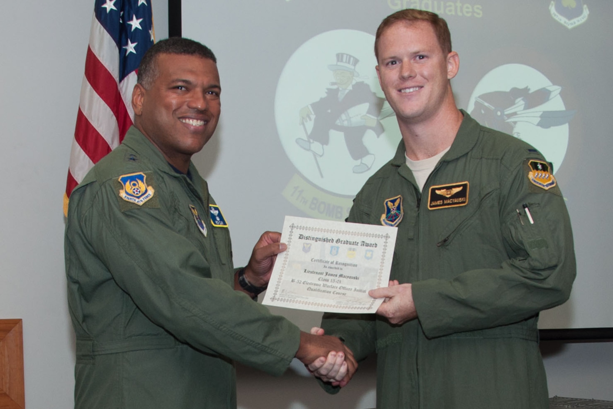 U.S. Air Force, Major General Richard Clark, commander of 8th Air Force, presents the Electronic Warfare Officer Distinguished Graduate Award to 1st Lt. James Macyauski during a Formal Training Unit (FTU) graduation ceremony, Aug. 19, 2015, Barksdale Air Force Base, La. Macyauski graduated from the FTU as an Electronic Warfare Officer on the B-52H Stratofortress. (U.S. Air Force photo by Master Sgt. Laura Siebert /Released)