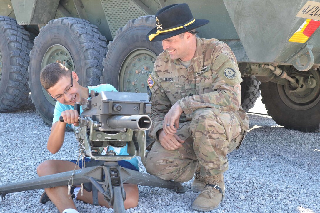 U.S. Army Staff Sgt. Quinton Flegel shows a young boy the weapon system of a Stryker Reconnaissance Vehicle during Polish Armed Forces Day activities at the National Football Stadium in Warsaw, Poland, Aug. 15, 2015. The U.S. Soldiers are in Poland as part of Operation Atlantic Resolve.