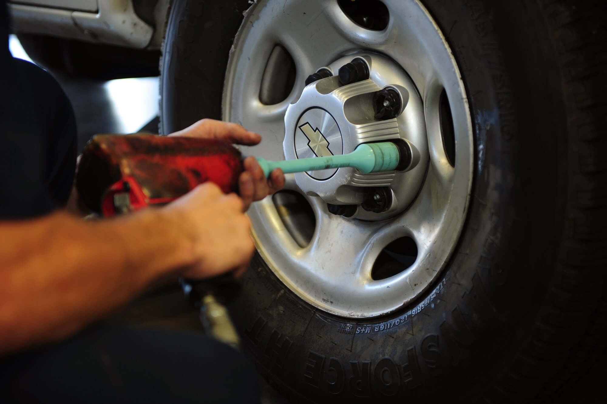 U.S. Air Force Senior Airman Richard McArdle, 355th Logistics Readiness Squadron Vehicle Management Flight customer service center vehicle maintenance journeyman, fastens a wheel center cap after performing a tire change at Davis-Monthan Air Force Base Ariz., Aug. 19, 2015. The customer service center’s Airmen troubleshoot vehicles and route work requests to the flight’s mechanics while focusing on quick turnaround maintenance tasks such as tire rotations, tire replacements and battery replacements. (U.S. Air Force photo by Airman 1st Class Chris Drzazgowski/Released)