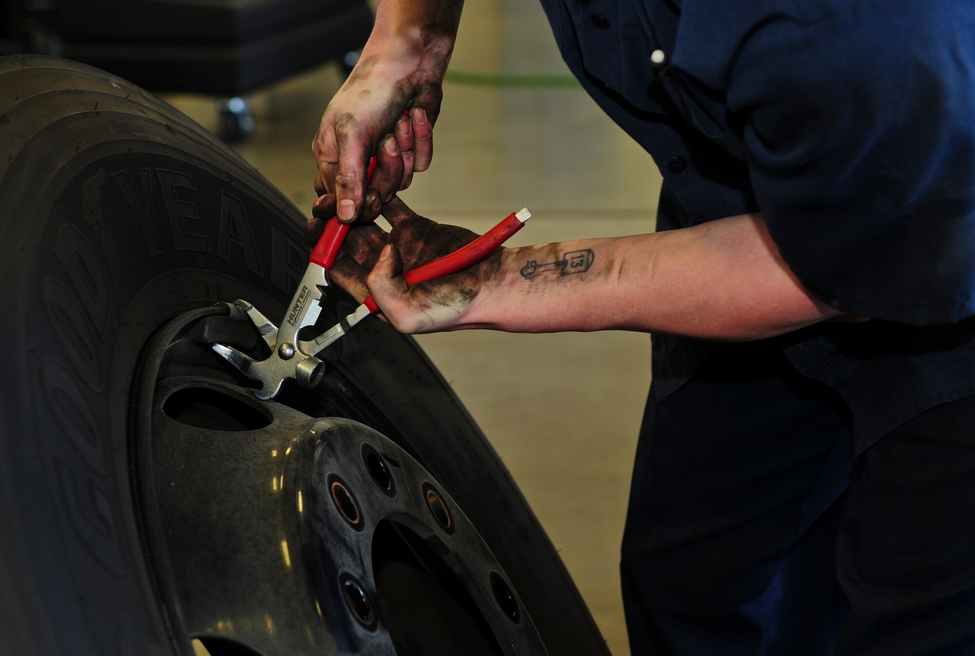 U.S. Air Force Senior Airman Kenneth Stanley, 355th Logistics Readiness Squadron Vehicle Management Flight customer service center vehicle maintenance journeyman, removes a wheel weight at Davis-Monthan Air Force Base Ariz., Aug. 19, 2015. Wheel weights are used to properly balance wheels and tires after they’ve been mounted together. (U.S. Air Force photo by Airman 1st Class Chris Drzazgowski/Released) 