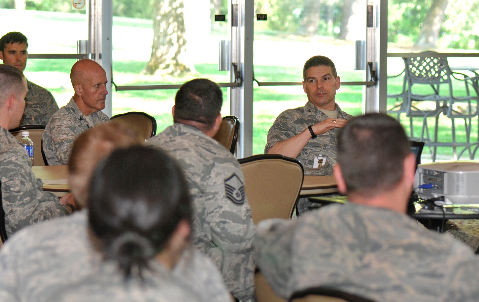 AEDC Commander Col. Raymond Toth (right) discusses suicide prevention with Airman at the Complex during training on May 8. The required suicide prevention training included the presentation of the acronym “ACE” on a resource card. “A” represented “Ask your wingman;” “C” represented “Care for your wingman;” and “E” represented “Escort your wingman.” The acronym provided suggestions on how Airman should communicate with a fellow wingman as well as providing resources for assistance. (Photo by Jacqueline Cowan)