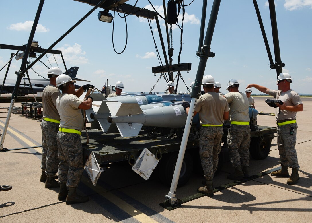 U.S. Air Force Tech. Sgt. Tyler Harrill, far right, 7th Munitions Squadron 7-level inspector, conducts a final inspection on a bomb-stacking exercise during the 2015 Global Strike Challenge Aug. 17, 2015, at Dyess Air Force Base, Texas. GSC assesses mission proficiency in a behind-the-scenes look at part of the operations of maintenance and munitions crews. (U.S. Air Force photo by Senior Airman Kedesha Pennant/Released)