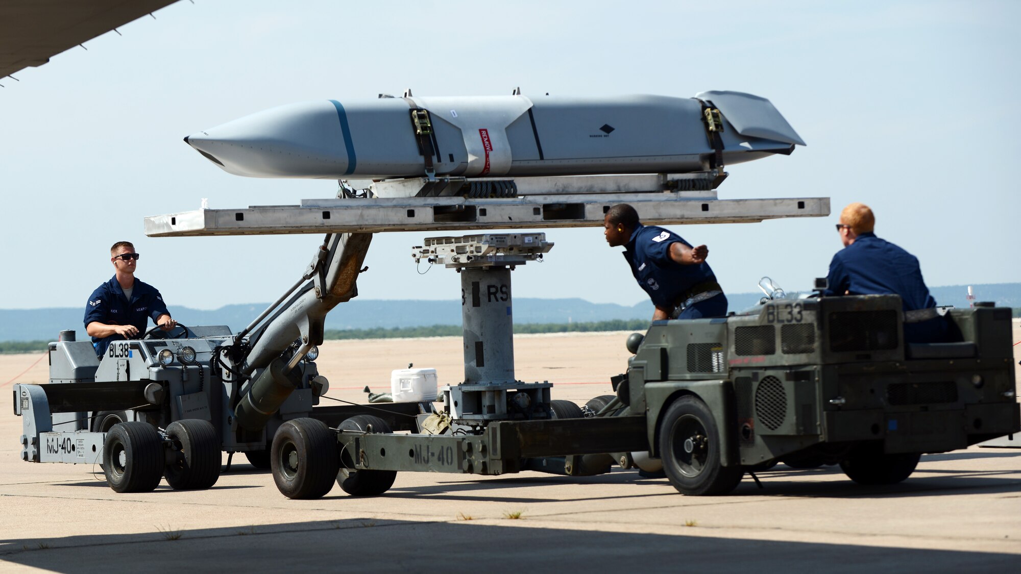 U.S. Air Force Airmen, assigned to the 7th Aircraft Maintenance Squadron, transfer a Joint Air-to-Surface Standoff Missile prior to loading it on a B-1B Lancer during the 2015 Global Strike Challenge Aug. 17, 2015, at Dyess Air Force Base, Texas. The loading of the missiles was one of three sub-competitions in the maintenance portion of the challenge. The maintainers were scored based upon the weapons load, equipment and tool organization, data management, dress and appearance and a written test. (U.S. Air Force photo by Senior Airman Kedesha Pennant/Released)