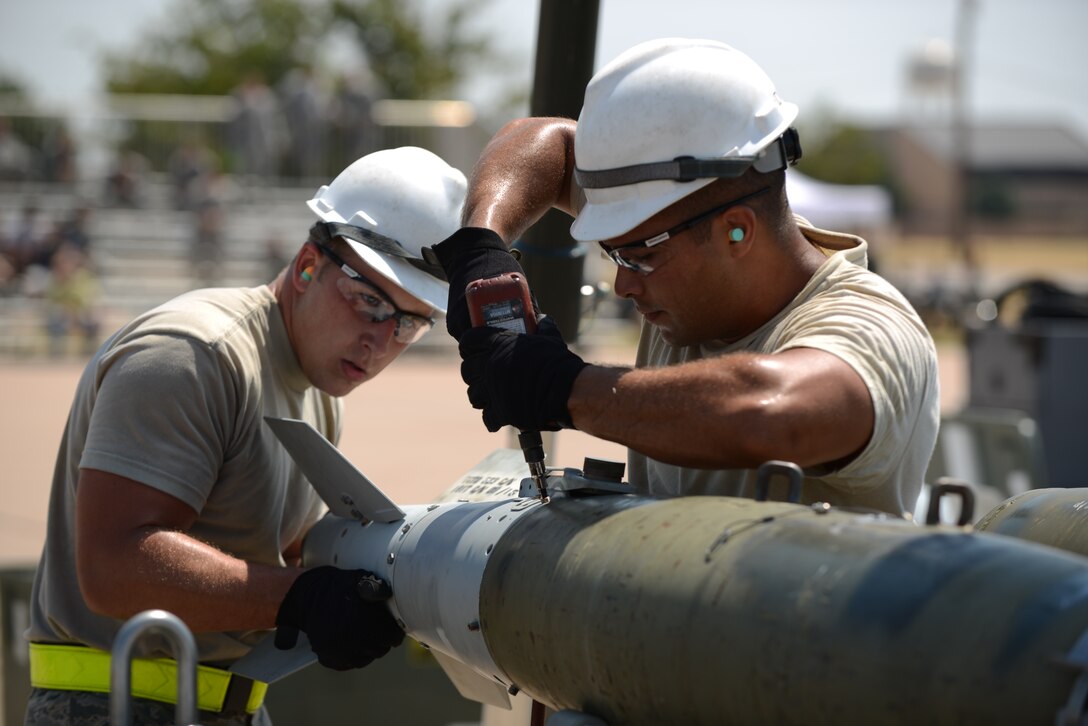 U.S. Air Force Airman 1st Class Brandon Chody, left, and Airman 1st Class Jeffery Hatmaker, both assigned to the 7th Munitions Squadron, install a tail fin on an inert-guided bomb unit during the 2015 Global Strike Challenge Aug. 17, 2015, at Dyess Air Force Base, Texas. During the competition, 7th MUNS crew members had to build 18 Joint Direct Attack Munitions and manufacture them on a munitions assembly conveyor in less than 90 minutes or be disqualified. (U.S. Air Force photo by Senior Airman Kedesha Pennant/Released)