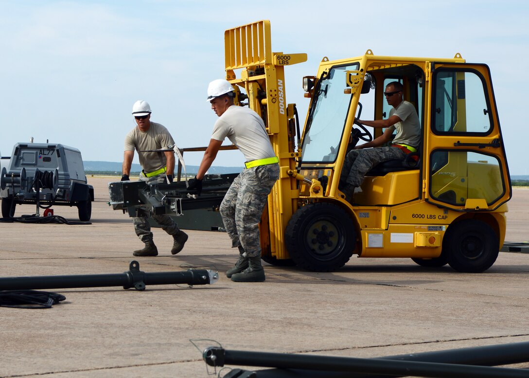 U.S. Air Force Airmen, assigned to the 7th Munitions Squadron, move parts for constructing a munitions assembly conveyor during the 2015 Global Strike Challenge Aug. 17, 2015, at Dyess Air Force Base, Texas. GSC is a national competition that boasts the world’s best bomber, maintenance and security forces personnel and units performing the Air Force global strike mission, which is to develop and provide combat-ready forces for nuclear deterrence and global strike operations. (U.S. Air Force photo by Senior Airman Kedesha Pennant/Released)