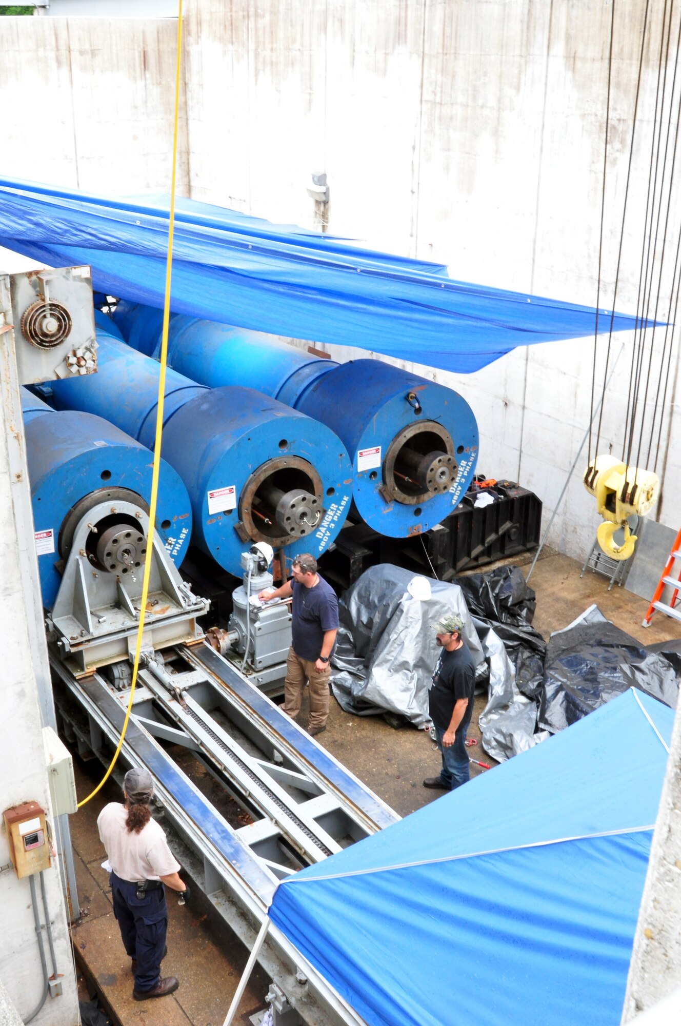 These three driver large vessels can be pressurized to 40,000 pounds per square inch and are one of the enabling technologies that make Hypervelocity Wind Tunnel 9 unique. During major maintenance they are rolled outside of the tunnel building into a maintenance bay. The gray steel fixture, pictured, is used to extract the central plug out of each driver vessel. (Photo by AJ Spicer)