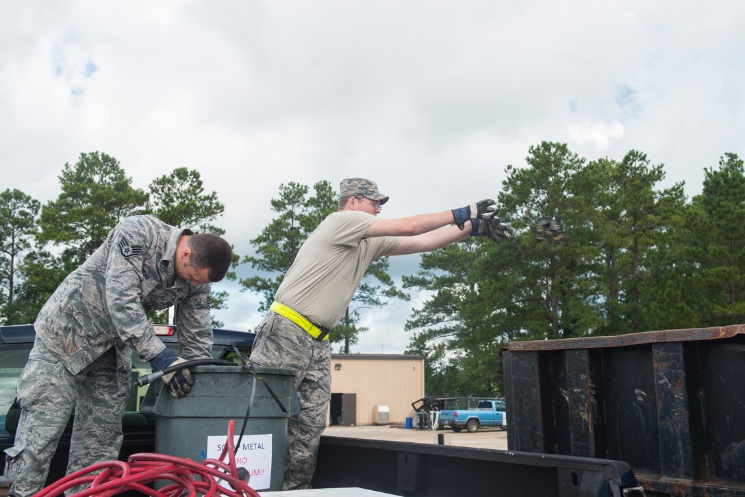U.S. Air Force Staff Sgt. Albert Lucas (left) and Senior Airman Justin Pennuell, 23d Equipment Maintenance Squadron armament technicians, dispose of scrap metal at the recycling center Aug. 20, 2015, at Moody Air Force Base, Ga. Moody’s recycling program contributes to minimizing negative impacts on the environment and earns the base approximately $20,000 annually. (U.S. Air Force photo by Airman 1st Class Ceaira Tinsley/Released)