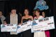 The top three winners of the Air Mobility Command Icon pose with their prize checks Aug. 14 at the Scott Club. Tracy Tinsley won first place, Airman 1st Class Andrea Aquino won second place, and Brian Flannigan claimed third place. (U.S. Air Force Photo by Senior Airman Megan Friedl)
