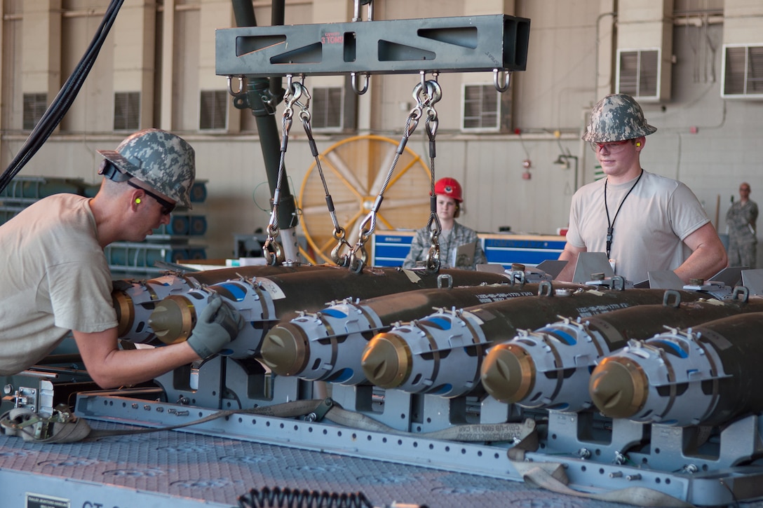 U.S. Air Force Senior Airmen Shawn Welch and Randon Rains, Airmen assigned to the 307th Maintenance Squadron, unload completed inert bombs off of the Munitions Assembly Conveyor and onto a trailer while being judged by Tech. Sgt. Ashley Wright, a Munitions Systems judge for the Global Strike Challenge Competition, on Barksdale Air Force Base, La. on Aug. 14, 2015. The team from the 307th Bomb Wing is competing for the Ellis Giant Sword Trophy which is awarded to the best conventional maintenance team in the Air Force Global Strike Command. (U.S. Air Force photo by Master Sgt. Dachelle Melville/Released)
