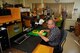 Temperature sensors and transducers are fabricated and installed on test models in the Aero-thermal Measurements Lab (ATML) at AEDC. ATML staff Randall Moon, Annette Painter and Stuart Coulter, pictured left to right, view heat flux sensors and model hardware through microscopes used in the lab. (Photo by Rick Goodfriend)