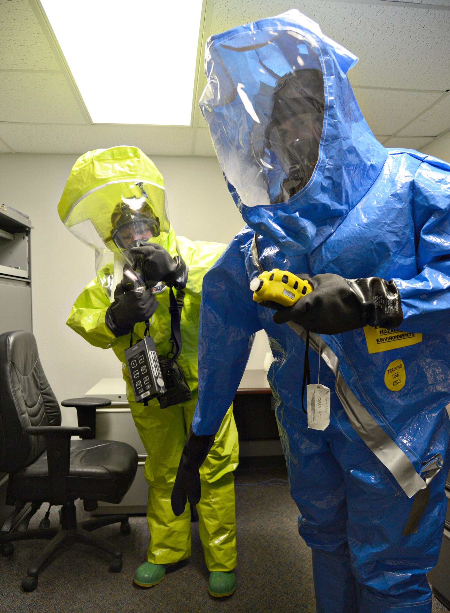 Lisa Kuefler, with Emergency Management, and Senior Airman Luis Villalva, from Bioenvironmental Engineering, monitor readings on their equipment for volatile organic compounds, air quality levels and radiation levels inside a simulated dining facility that held a suspected biological hazard (plague) during last week’s CBRNE exercise. The suits they are wearing are Level A with SCBA, a fully encapsulated suit, which is the highest level of Personal Protective Equipment. The team conducted an All-Hazards approach to ensure no other risks were present. (Air Force photo by Kelly White/Released)


