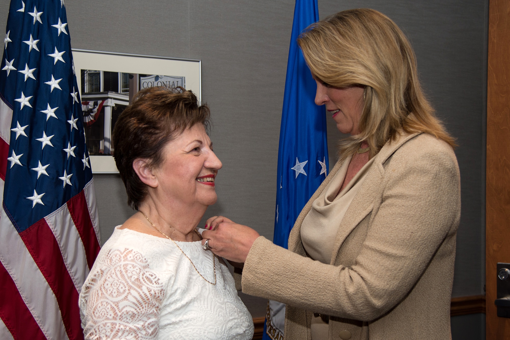 Maria Bandouveres is presented a 70-year federal service pin by Secretary of the Air Force Deborah Lee James during a recognition ceremony in Building 1606 Aug. 21. James also presented Bandouveres with her personal challenge coin in recognition of her long career that has supported 20 commanders and program executive officers. (U.S. Air Force photo by Mark Herlihy) 