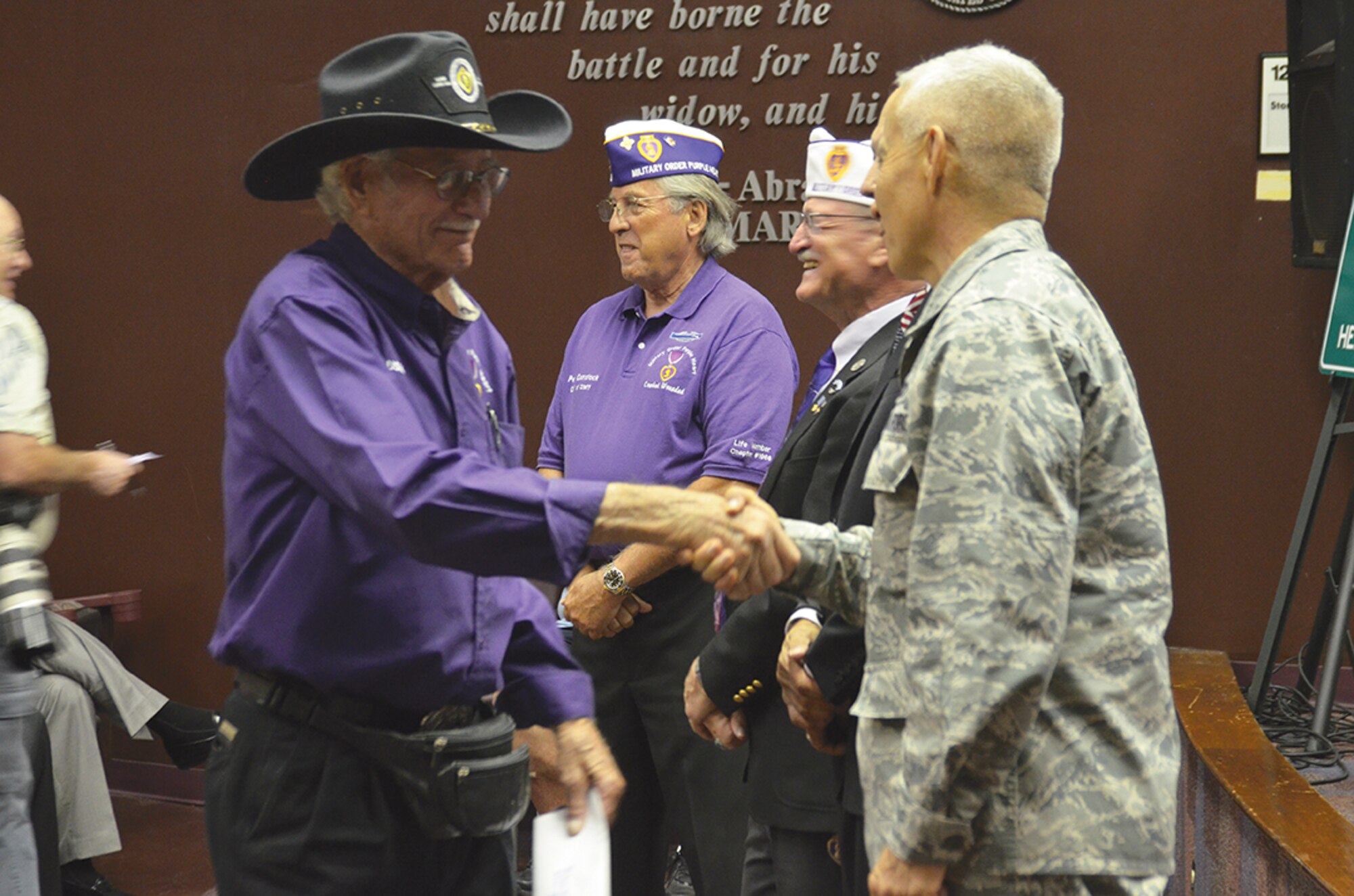Richard Gibbs, a Marine Corps veteran, shakes hands with Brig. Gen. Andrew Salas, New Mexico National Guard Adjutant General, during a ceremony to honor Purple Heart recipients. Around 75 people attended the Aug. 13 event at the VA center’s Education Auditorium, which was held in honor of those who were injured in combat. (Photo by Lee Ross)