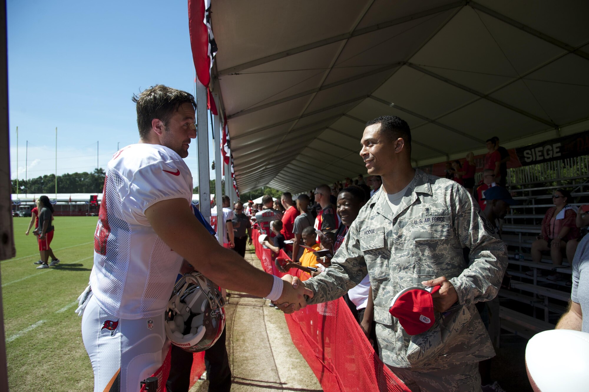 Master Sgt. Correy Hodge, 6th Air Mobility Wing Medical Logistics, flight chief, meets Luke Stocker, Tampa Bay Buccaneers, tight end.   Military members from MacDill Air Force Base showed up in force to cheer on their hometown team, the Tampa Bay Buccaneers. Closed to the general public, the Bucs opened their gates and completed their final day of training camp with a Salute to the Military. (U.S. Air Force Photo/Tech. Sgt. Peter Dean)
