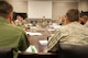 Lt. Col. Jeffrey Donnithorne, Deputy Director of the Center for Strategy and Technology,(center) leads Air Command and Staff College students in a discussion in the new Secure Research Wing at Maxwell Air Force Base, Aug. 18, 2015. The new research facility provides a protected area for Air University students and faculty to access current Air Force doctrine as well as secure computer and video teleconference systems for collaboration and research. (U.S. Air Force photo by Tech. Sgt. Sarah Loicano/Released)
