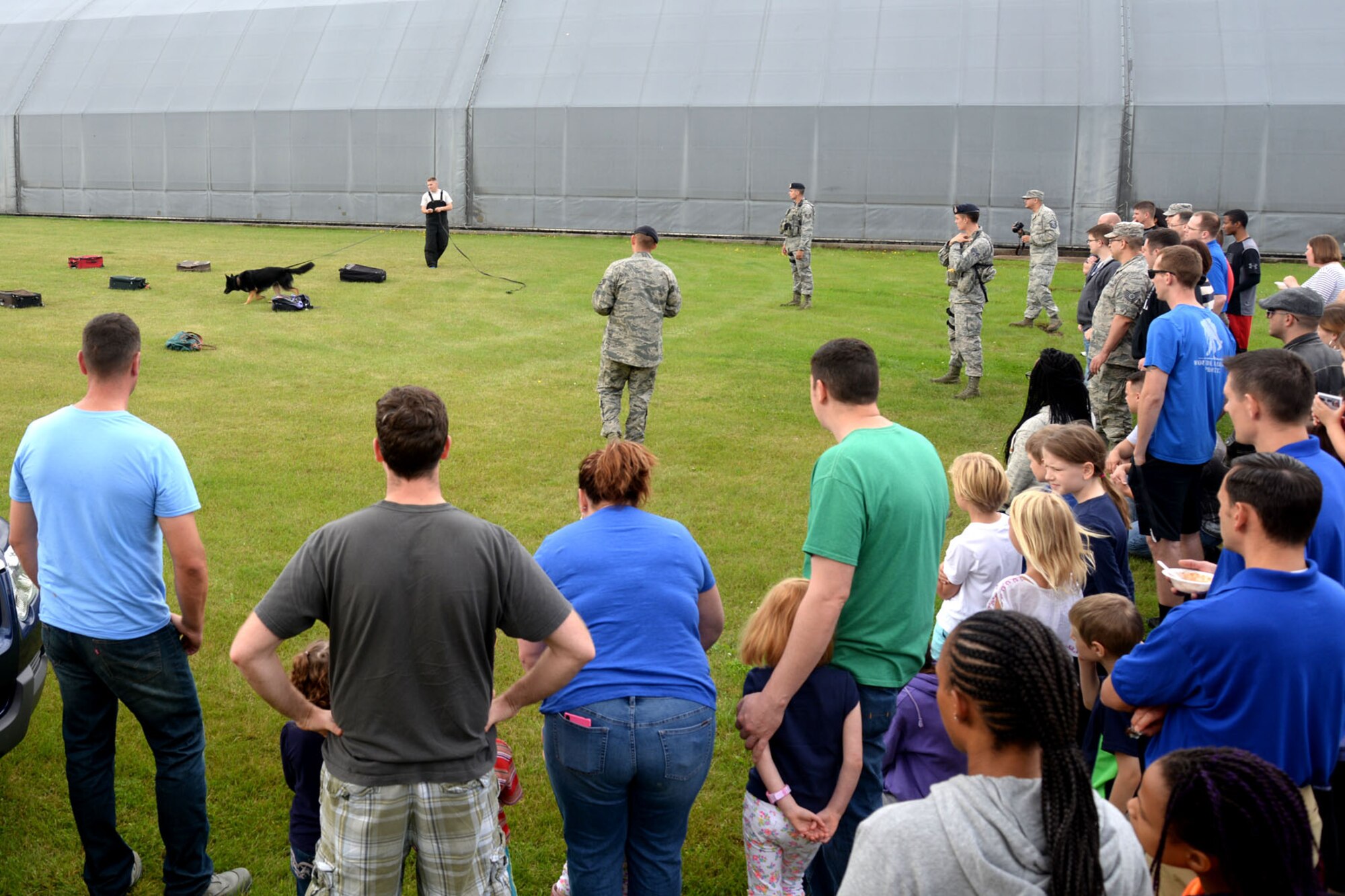 U.S. Air Force Airmen and their families watch a 100th Security Forces Squadron Military Working Dogs demonstration during the 95th Reconnaissance Squadorn birthday celebration Aug. 20, 2015, on RAF Mildenhall, England. The celebration included a historical briefing, dodgeball tournament, chili cook-off and demonstration from the 100th SFS MWD section. (U.S. Air Force photo by Senior Airman Kate Thornton/Released)