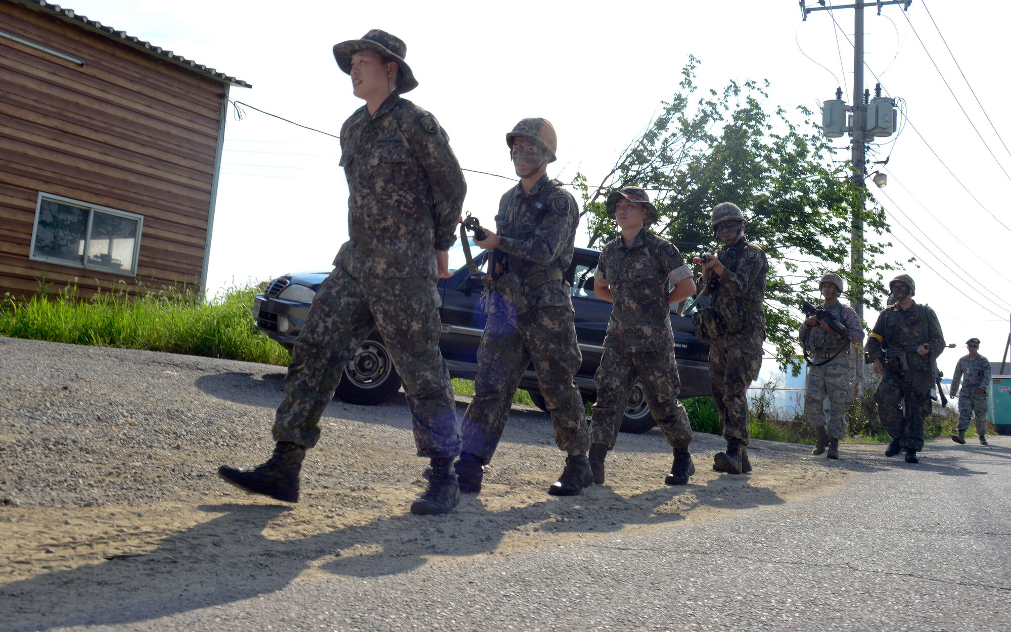 Simulated opposition forces are escorted during a joint mission in a training area outside Osan Air Base, Republic of Korea, Aug. 18, 2015. The joint mission conducted was part of readiness exercise Beverly Midnight 15-03. This exercise helps identify areas where procedures should be changed or equipment added in order to enhance the emergency response capabilities. The joint mission focuses on communication between the 51st Security Forces Squadron defenders and ROK army soldiers. (U.S. Air Force photo/ Senior Airman Kristin High)