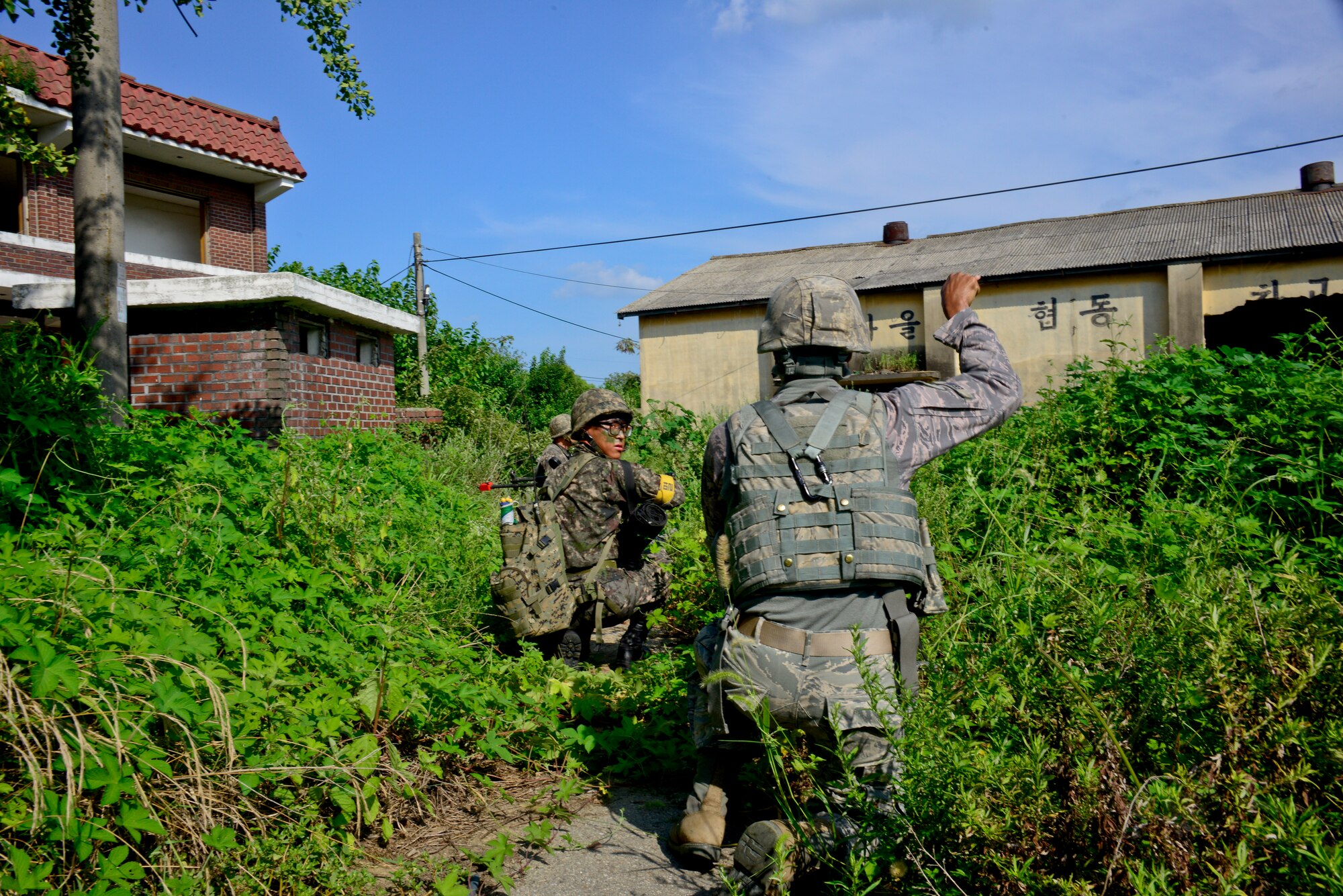 Airman 1st Class Donte Estes, 51st Security Forces Squadron patrolman, makes hand signals to his fire team during a joint mission as part of readiness exercise Beverly Midnight 15-03 in a training area outside Osan Air Base, Republic of Korea, Aug. 18, 2015. The ROK army teams up with the 51st SFS to conduct various training scenarios to practice communication and various tactical strategies in the event of a real world incident. (U.S. Air Force photo/Senior Airman Kristin High)