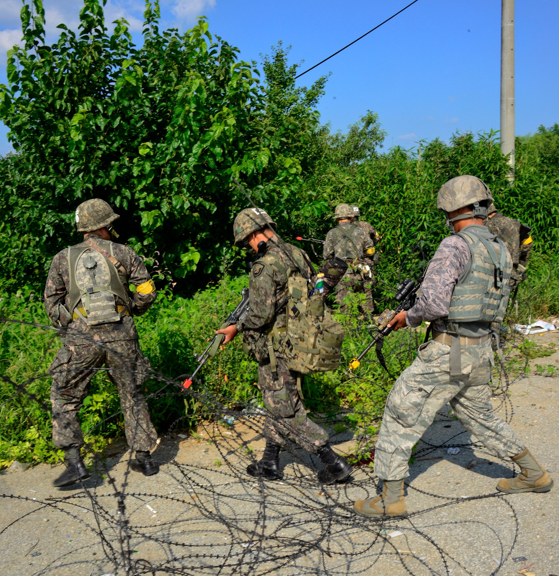 Republic of Korea army soldiers and 51st Security Forces Squadron defenders, cross over c-wire during a joint mission as part of readiness exercise Beverly Midnight 15-03 in a training area outside Osan Air Base, ROK, Aug. 18, 2015. The exercise focuses on readiness, testing Osan’s wartime procedures, and realistically looking at our ability to defend the base, execute operations and receive follow-on forces.  (U.S. Air Force photo/Senior Airman Kristin High)                                                                                                                                                                                                                                                 