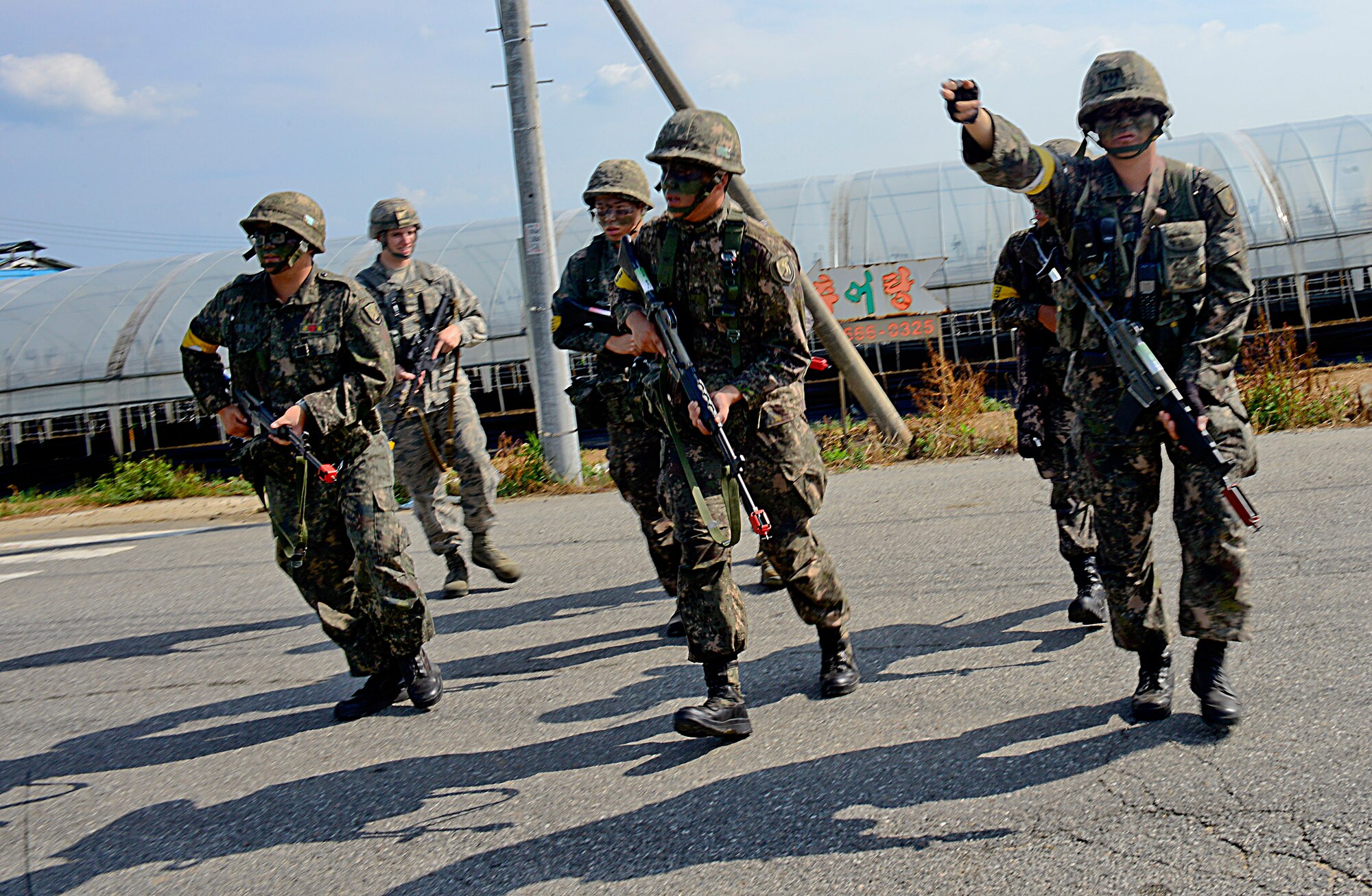 Capt. Moon Hu Choi, Republic of Korea army 4th Battalion 169th Regiment soldier, signals to ROKA soldiers and 51st Security Forces Squadron Defenders, during a joint mission as part of readiness exercise Beverly Midnight 15-03 in a training area outside Osan Air Base, ROK, Aug. 18, 2015. Throughout the mission, the Airmen and soldiers search for opposition forces role players, intended to simulate potential real-world conditions. (U.S. Air Force photo/Senior Airman Kristin High)