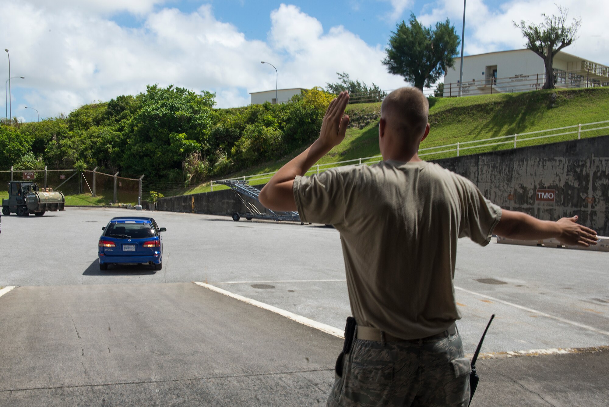 U.S. Air Force Staff Sgt. James Wilson, 18th Logistics Readiness Squadron vehicle operator, marshals a government vehicle into a storage unit on Kadena Air Base, Japan, to prevent damage during a typhoon Aug. 21, 2015. Each time a typhoon moves too close to Okinawa, it is standard procedure for units like the 18th LRS to move vehicles and other equipment into storage to protect them from the resulting strong winds and debris associated with the storm. If it remains on course and at its current speed, Typhoon Goni is expected to hit Okinawa within the next few days. (U.S. Air Force photo by Staff Sgt. Maeson L. Elleman)