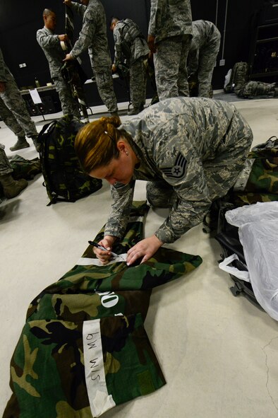 Staff Sgt. Natlin Seese, 51st Security Forces Squadron NCO in-charge of police services, labels her chemical warfare gear with “SIM M-9” paper on Osan Air Base, Republic of Korea, Aug. 18, 2015. The simulated paper is used for simulated chemical detection during the readiness exercise, Beverly Midnight 15-03. (U.S. Air Force photo/Senior Airman Kristin High)
