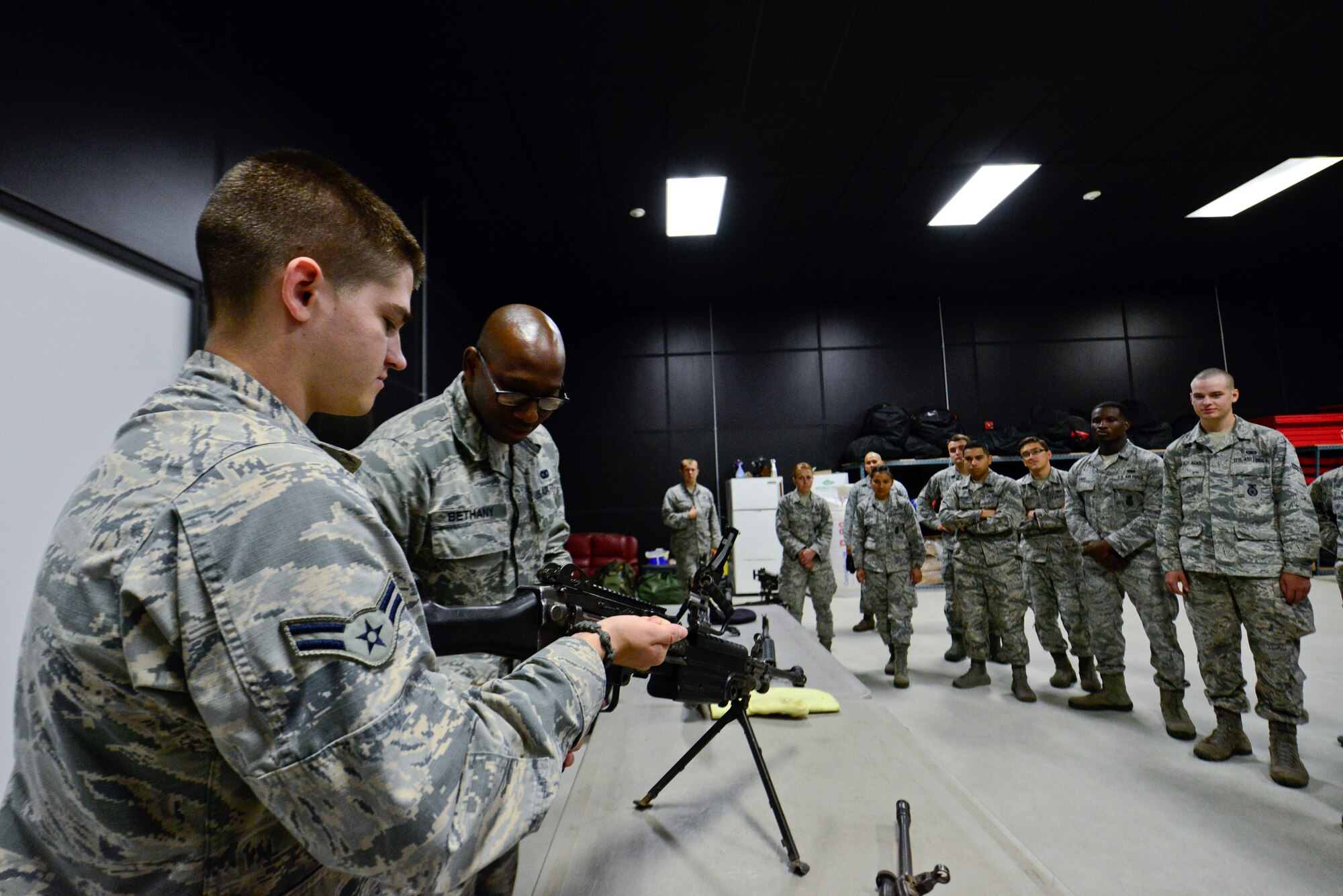Airman 1st Class Robert Dunn, 51st Security Forces Squadron alarm monitor, is observed by Staff Sgt. Terrance Bethany, 51st SFS combat arms instructor, on properly reloading an M-249 automatic rifle on Osan Air Base, Republic of Korea, Aug. 18, 2015. The 51st SFS prepared for the upcoming readiness exercise, Beverly Midnight 15-03. The exercise is conducted to test Osan Airmen’s abilities during a heightened state of readiness while providing combat ready forces for close air support, air strike control, counter air, interdiction, theater airlift and communications in the defense of the ROK. (U.S. Air Force photo/Senior Airman Kristin High)