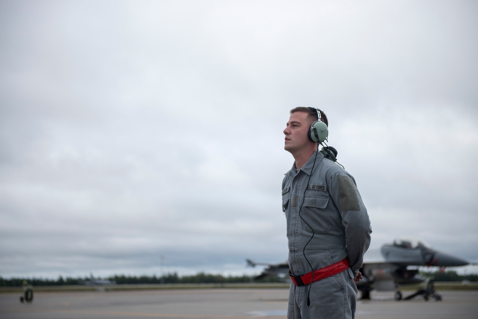 U.S. Air Force Airman 1st Class Jason Watson, a 354th Aircraft Maintenance Squadron crew chief, waits to marshal an 18th Aggressor Squadron F-16 Fighting Falcon, Aug. 19, 2015, prior to the launch of a RED FLAG-Alaska (RF-A) 15-3 sortie from Eielson Air Force Base, Alaska. Airmen with the 354th Maintenance Group ensure the Aggressors can maximize training for participants of RF-A, a Pacific Air Forces commander-directed field training exercise for U.S. and partner nation forces, providing combined offensive counter-air, interdiction, close air support and large force employment training in a simulated combat environment. (U.S. Air Force photo by 1st Lt. Elias Zani/Released)