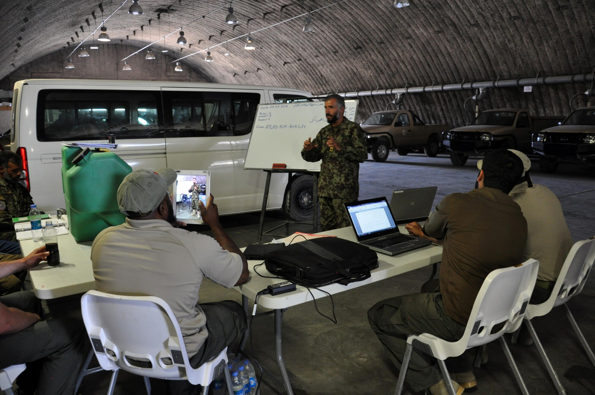 An Afghan National Army vehicle maintainers practices “teaching techniques” with contractors during an instructor certification session at Kabul Air Wing Aug. 6, 2015. Train, Advise, Assist Command – Air (TAAC-Air) advisors and contractors work to refine Afghan Air Force logistics, reduce new acquisitions and programs, and create a sustainable and capable air force to support the Afghan National Security Forces in the coming years. The Vehicle Maintenance Training Program (VMTP) is one focus area to acquire coalition expertise to provide meaningful instruction on specialized equipment and contractor support to the AAF. They began training June 27, 2015. (U.S. Air Force courtesy photo/Released)