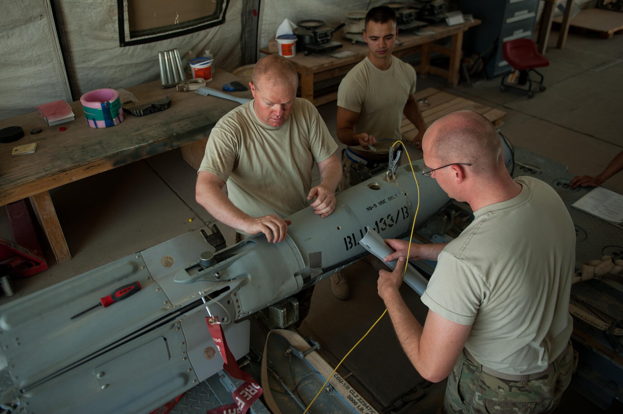 U.S. Airmen assigned to the 62nd Expeditionary Reconnaissance Squadron munitions flight, build a GPS-guided GBU-49 weapon at Kandahar Airfield, Afghanistan, Aug. 15, 2015.  The 62nd ERS Munitions Flight ensures that every munition loaded onto an MQ-1 Predator and MQ-9 Reaper will perform as expected when used. (U.S. Air Force photo by Tech. Sgt. Joseph Swafford/Released)