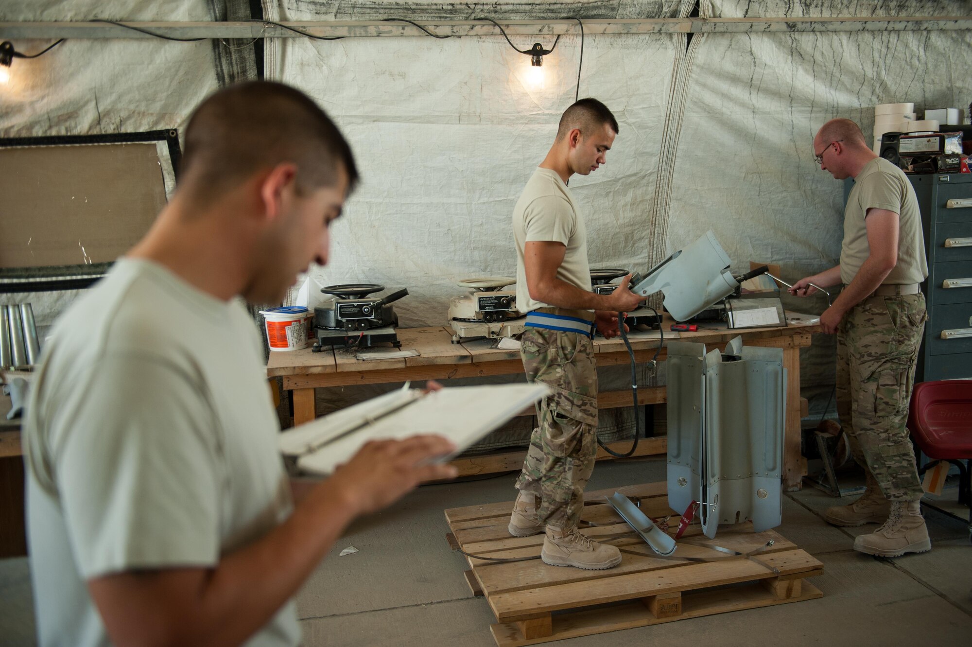 U.S. Air Force Airman 1st Class Matthew Lopez, center, 62nd Expeditionary Reconnaissance Squadron munitions systems technician, builds a GPS-guided GBU-49 weapon at Kandahar Airfield, Afghanistan, Aug. 15, 2015.  The 62nd ERS Munitions Flight ensures that every munition loaded onto an MQ-1 Predator and MQ-9 Reaper will perform as expected when used. (U.S. Air Force photo by Tech. Sgt. Joseph Swafford/Released)