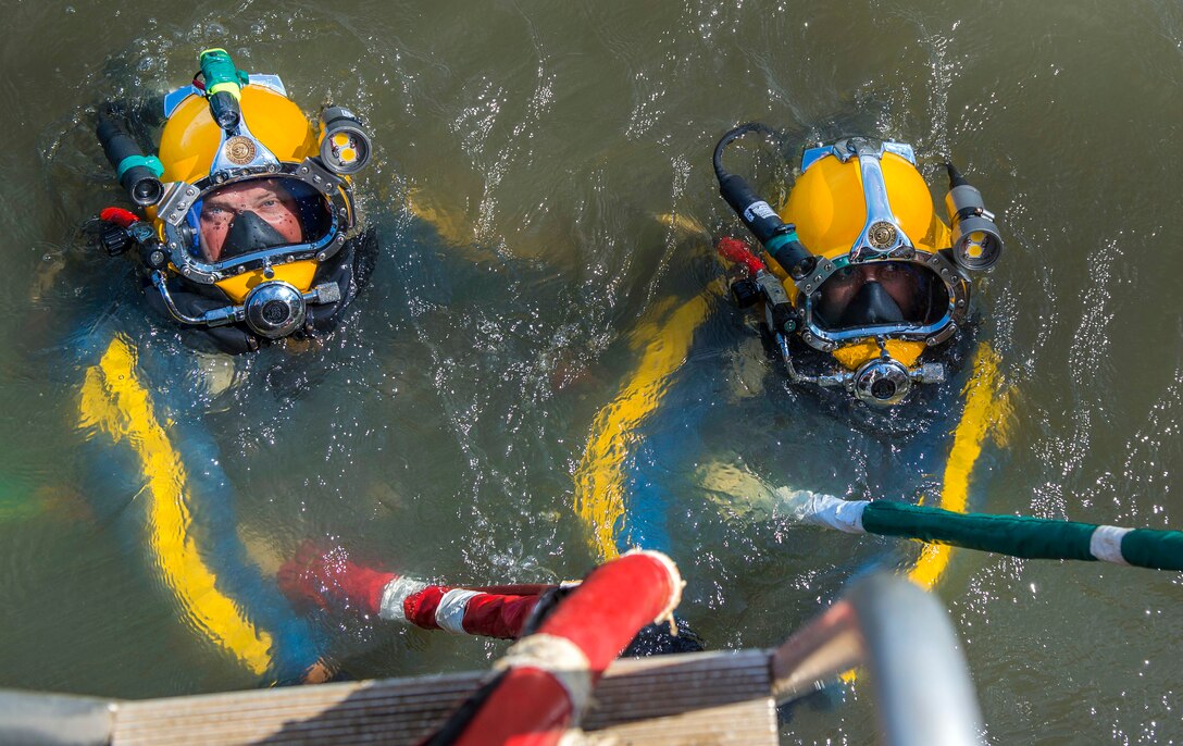 Navy Chief Warrant Officer 3 Jason Potts, left, and Navy Petty Officer 1st Class Fernando Almazan begin their decent to the CSS Georgia for salvage operations in the Savannah River in Savannah, Ga., Aug. 15, 2015. Potts is an on-scene commander, Task Element CSS Georgia steamship. Almazan is a diver assigned to Mobile Diving and Salvage Unit 2. U.S. Navy photo by Petty Officer 1st Class Blake Midnight