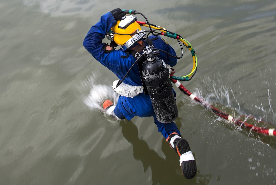 Navy Petty Officer 1st Class Calum Sanders jumps into the Savannah River to conduct salvage operations on the SCC Georgia in Savannah, Ga., Aug. 17, 2015. Sanders is a diver assigned to Mobile Diving and Salvage Unit 2. U.S. Navy photo by Petty Officer 1st Class Blake Midnight