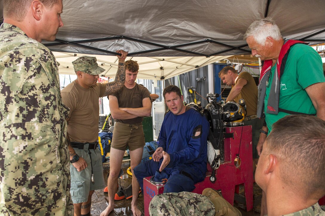 Navy Petty Officer 1st Class Calum Sanders, center, describes the condition of CSS Georgia steamship at the bottom of the Savannah River in Savannah, Ga., Aug. 17, 2015, to other members of the team,as they work out a plan to salvage what’s left of the ship. U.S. Navy photo by Petty Officer 1st Class Blake Midnight