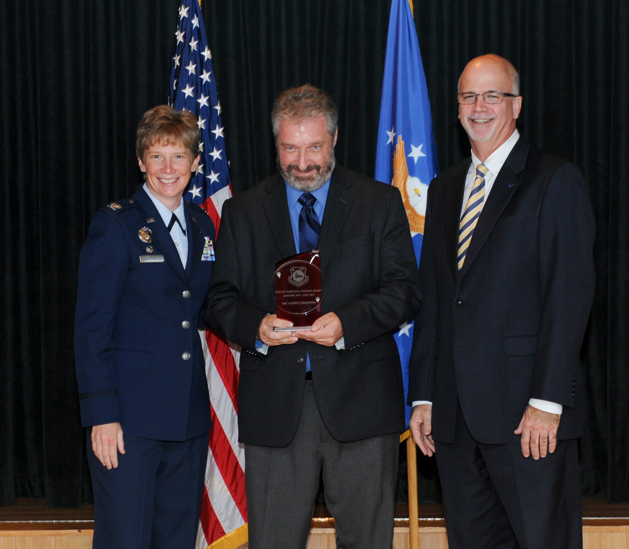 WRIGHT-PATTERSON AIR FORCE BASE, Ohio -- Glenn Johnansen, National Air and Space Intelligence Center employee, received the Maj. Gen. Harold E. Watson Award from Col. Leah Lauderback, NASIC commander and Curt Rowland, NASIC chief scientist, here Aug. 18. The Watson award is given to an individual that has placed NASIC at the top of their personal priorities, and is a selfless champion for NASIC and its people, and is completely dedicated to organizational service. (U.S. Air Force Photo by Airman 1st Class Samuel Earick)   