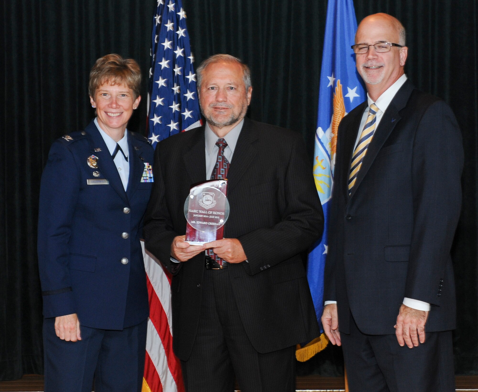 WRIGHT-PATTERSON AIR FORCE BASE, Ohio – Edward Creehan, retired National Air and Space Intelligence Center employee, receives the NASIC Wall of Honor award from Col. Leah Lauderback, NASIC commander and Curt Rowland, NASIC chief scientist, here Aug. 19, 2015.The Wall of Honor is the greatest honor that NASIC can bestow on one of its alumni, It recognizes their significant achievements and is a reflection of their lasting, positive contributions to the center. (U.S. Air Force Photo by Airman 1st Class Samuel Earick)