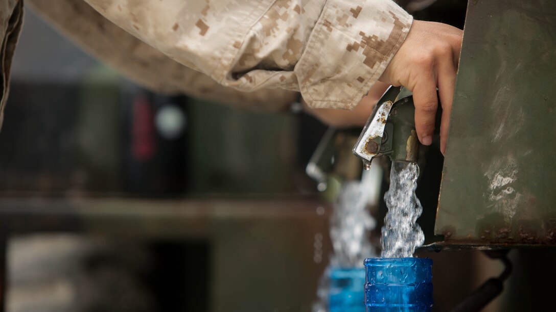 A U.S. Marine with Combat Logistics Battalion 31, 31st Marine Expeditionary Unit, fills water jugs for civilians during typhoon relief efforts in Saipan, Aug. 14, 2015.  The Marines with Echo Company, Battalion Landing Team 2nd Battalion, 5th Marines, 31st MEU and CLB 31, 31st MEU, assisted the locals of Saipan by producing and distributing potable water. The Marines and sailors of the 31st MEU were conducting training near the Mariana Islands when they were redirected to Saipan after the island was struck by Typhoon Soudelor Aug. 2-3.
