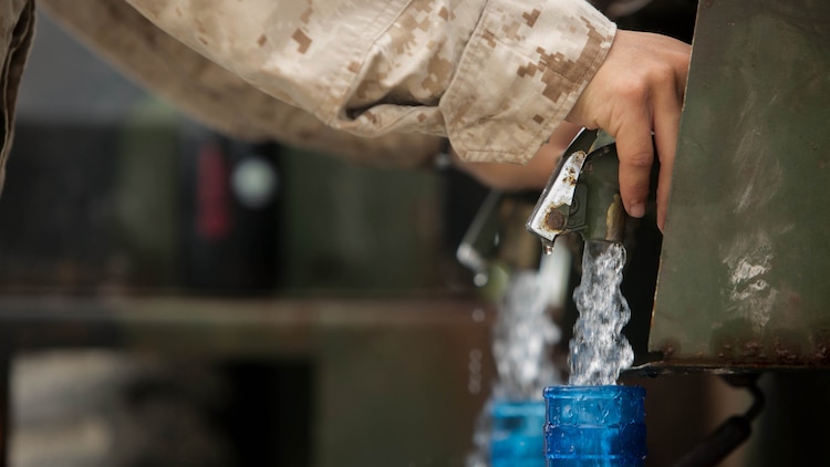 A U.S. Marine with Combat Logistics Battalion 31, 31st Marine Expeditionary Unit, fills water jugs for civilians during typhoon relief efforts in Saipan, Aug. 14, 2015.  The Marines with Echo Company, Battalion Landing Team 2nd Battalion, 5th Marines, 31st MEU and CLB 31, 31st MEU, assisted the locals of Saipan by producing and distributing potable water. The Marines and sailors of the 31st MEU were conducting training near the Mariana Islands when they were redirected to Saipan after the island was struck by Typhoon Soudelor Aug. 2-3.