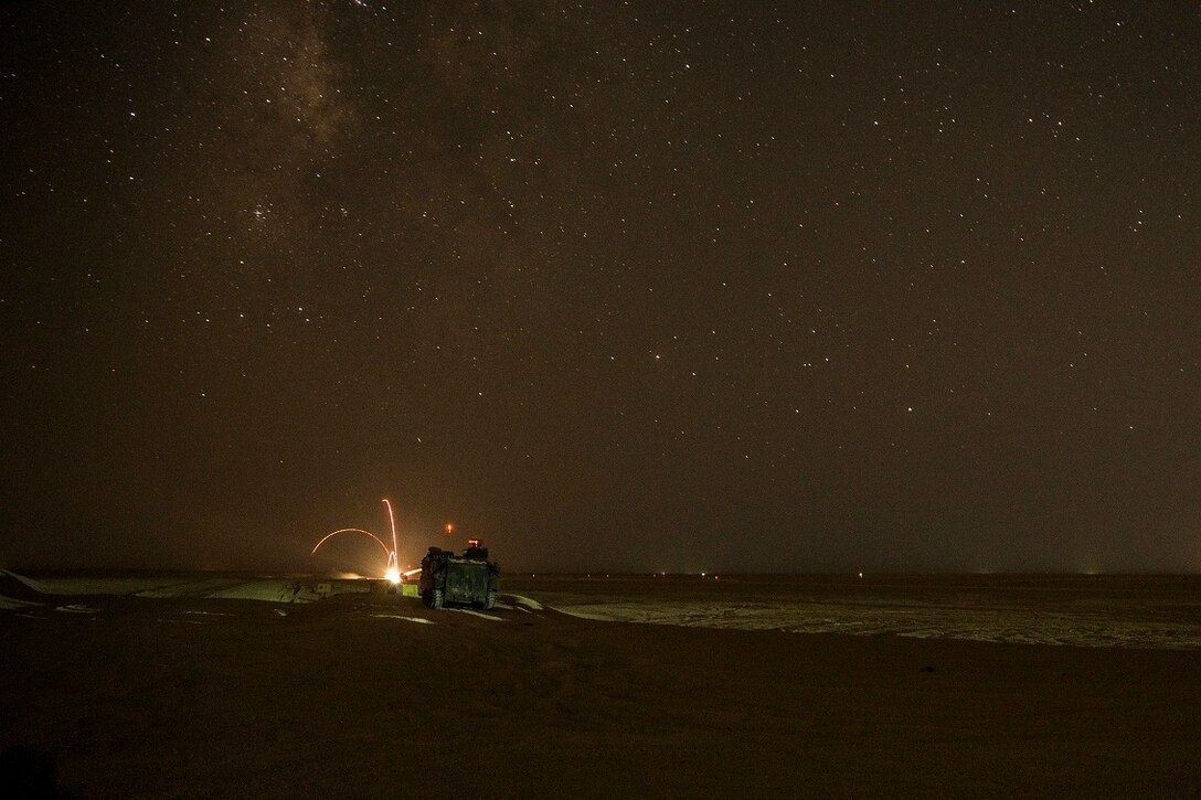 KUWAIT (Aug. 19, 2015) U.S. Marines with Kilo Company, Battalion Landing Team 3rd Battalion, 1st Marine Regiment, 15th Marine Expeditionary Unit (MEU), observe a night live-fire and maneuver exercise. During the training, Marines used night vision devices to engage targets with the Browning .50 caliber machine gun at unknown distances from Amphibious Assault Vehicles (AAV-7). Elements of the 15th MEU are ashore in Kuwait for sustainment training to maintain and enhance the skills they developed during their pre-deployment training period.  The 15th MEU is embarked on the Essex Amphibious Ready Group and deployed to maintain regional security in the U.S. 5th Fleet area of operations. (U.S. Marine Corps photo by Sgt. Emmanuel Ramos/Released)