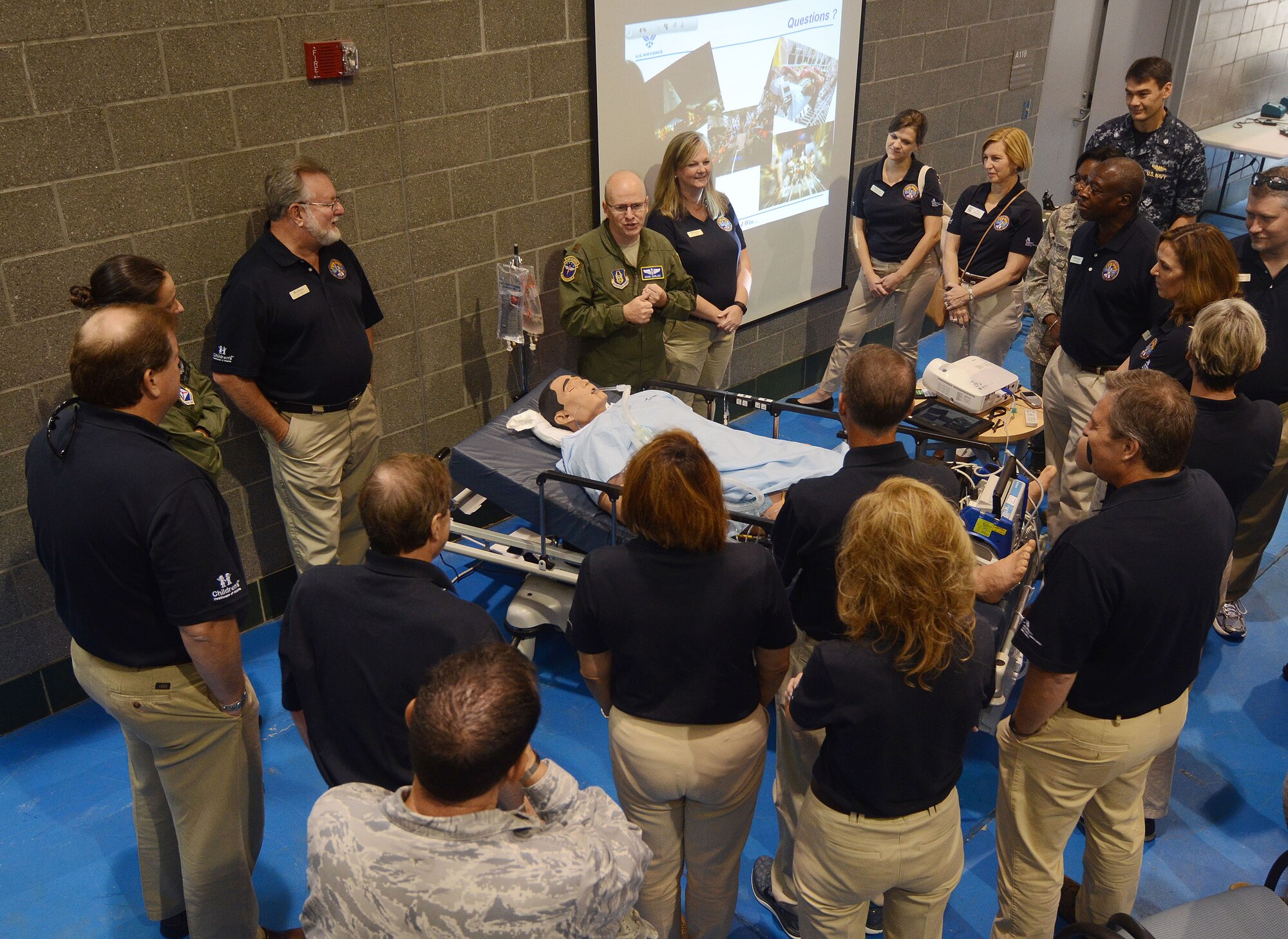 Maj. Chad Corliss Director of Operations with the 94th Aeromedical Evacuation Squadron briefs members of the Honorary Commanders Association on medical training received by reservists assigned to AES. Corliss also demonstrated functions of real-like mannequins used to prepare medical teams for mission objectives. The HCA visited various units during a Dobbins Day base tour held on Dobbins Air Reserve Base, Ga. Aug 19, 2015. 