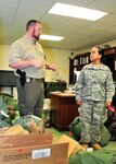 U.S. Army Sgt. Iliana Guillen, supply specialist for the 351st Headquarters Support Company, South Carolina Army National Guard, discusses how she would barricade her office door and where she would hide within her office with South Carolina Law Enforcement Division agent Wayne Freeman during the unit's active shooter training class partnered with SLED and the Sumter county Sheriff's Department at the Army National Guard Armory in Sumter, South Carolina, Aug. 21, 2015.