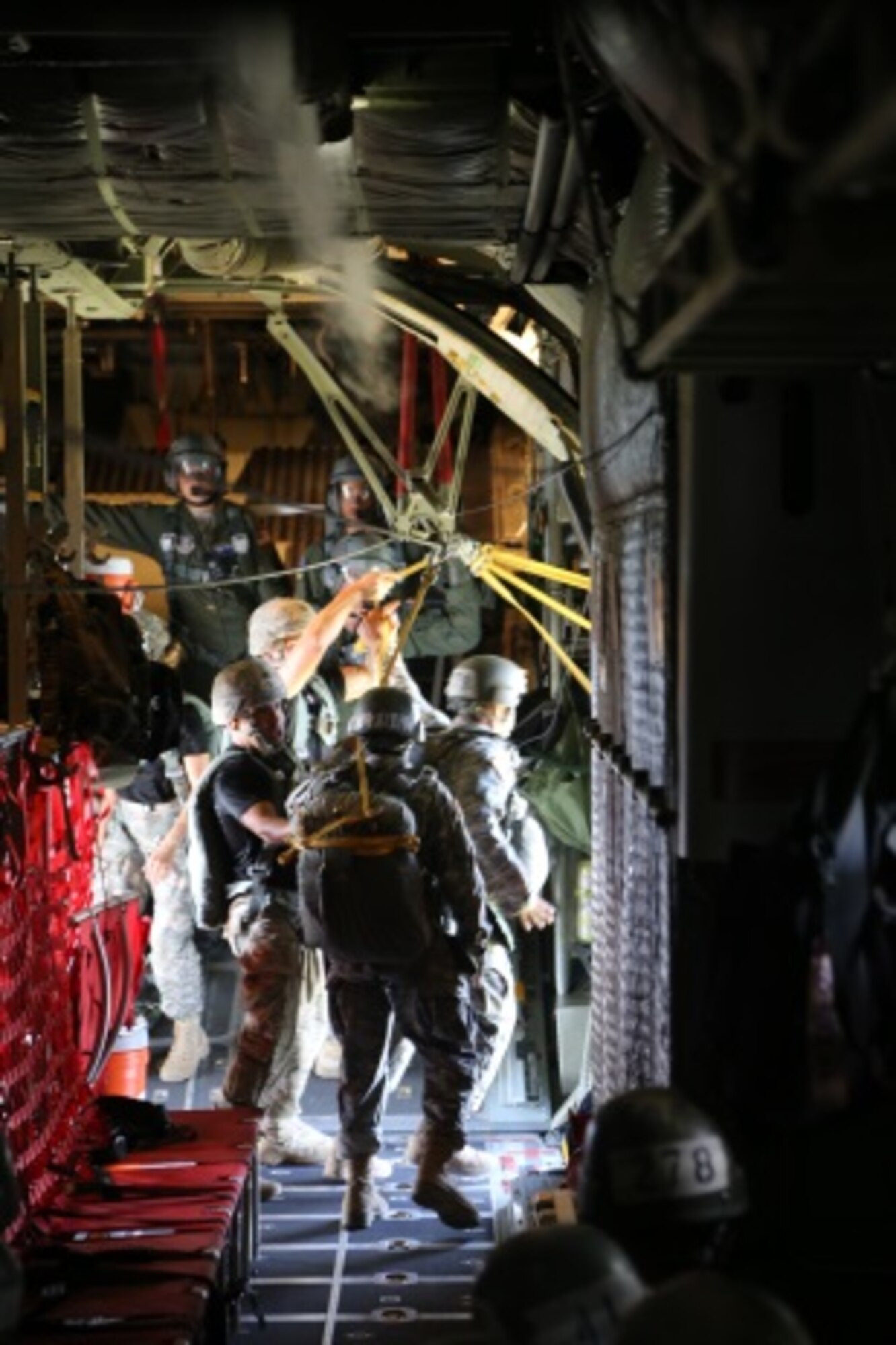 Basic Airborne Course students exit a C-130H by shuffling towards the door at Fort Benning, Ga. July 13, 2015. Graduation requires each student to make five jumps. Two of the jumps are "combat equipment jumps," in which the jumper carries a Molle ruck with Modular Airborne Weapons Case and a dummy weapon. Three jumps are "Hollywood," in that the jumper only wears the parachute and reserve. The last jump will culminate combining the combat equipment with a night jump, giving the student a complete understanding of a night combat equipment jump. (U.S. Air Force photo/Maj. Mark Withee)