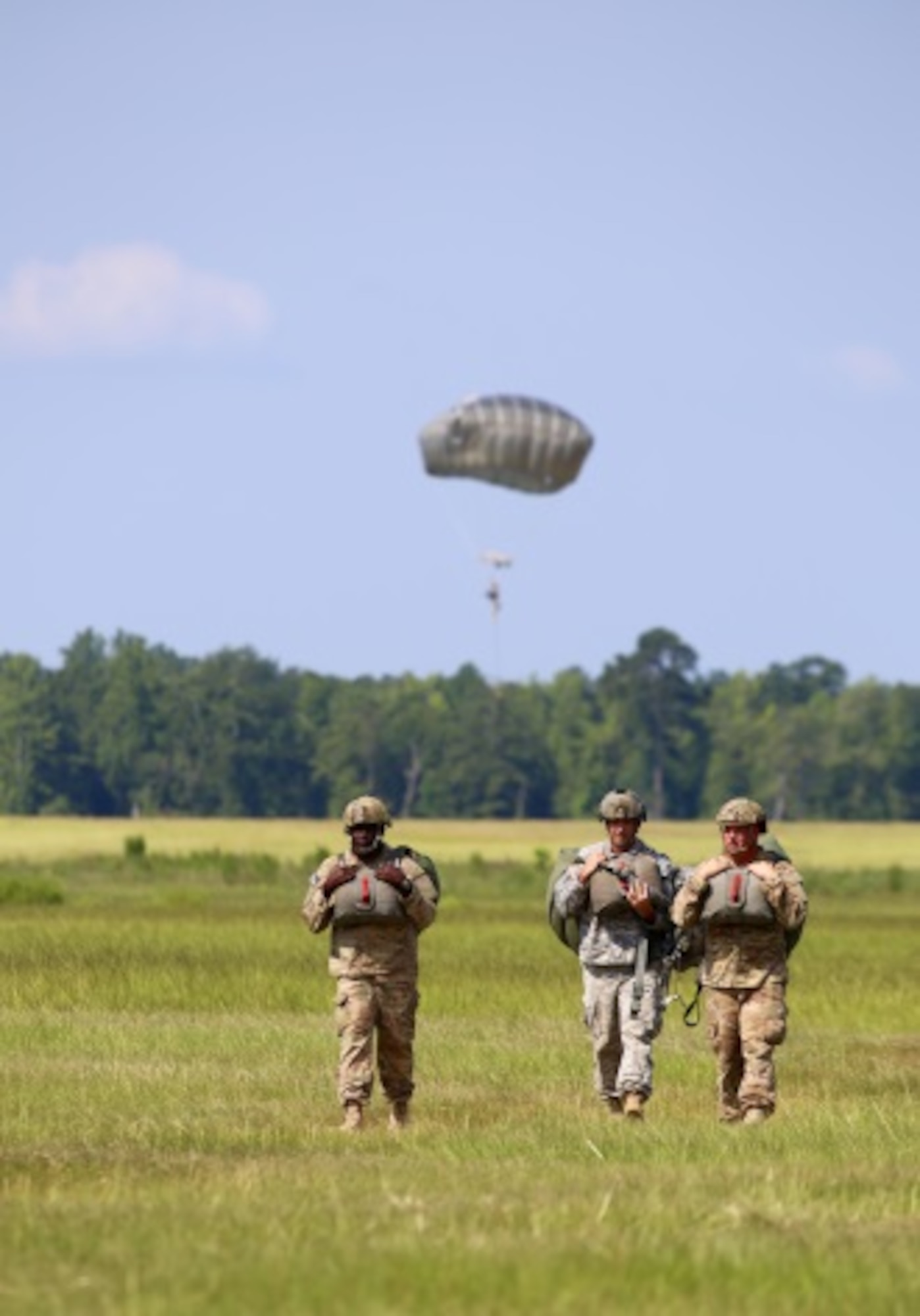 Student paratroopers walk to a designated area after making a successful jump and landing on Fryar Field drop zone at Fort Benning, Ga. July 13, 2015. Proper parachute landings are a key component of the Basic Airborne Course. During the first week, often referred to as “Ground Week,” students are taught the proper procedures and develop the necessary skills to jump, and land safely.  (U.S. Air Force photo/Maj. Mark Withee)