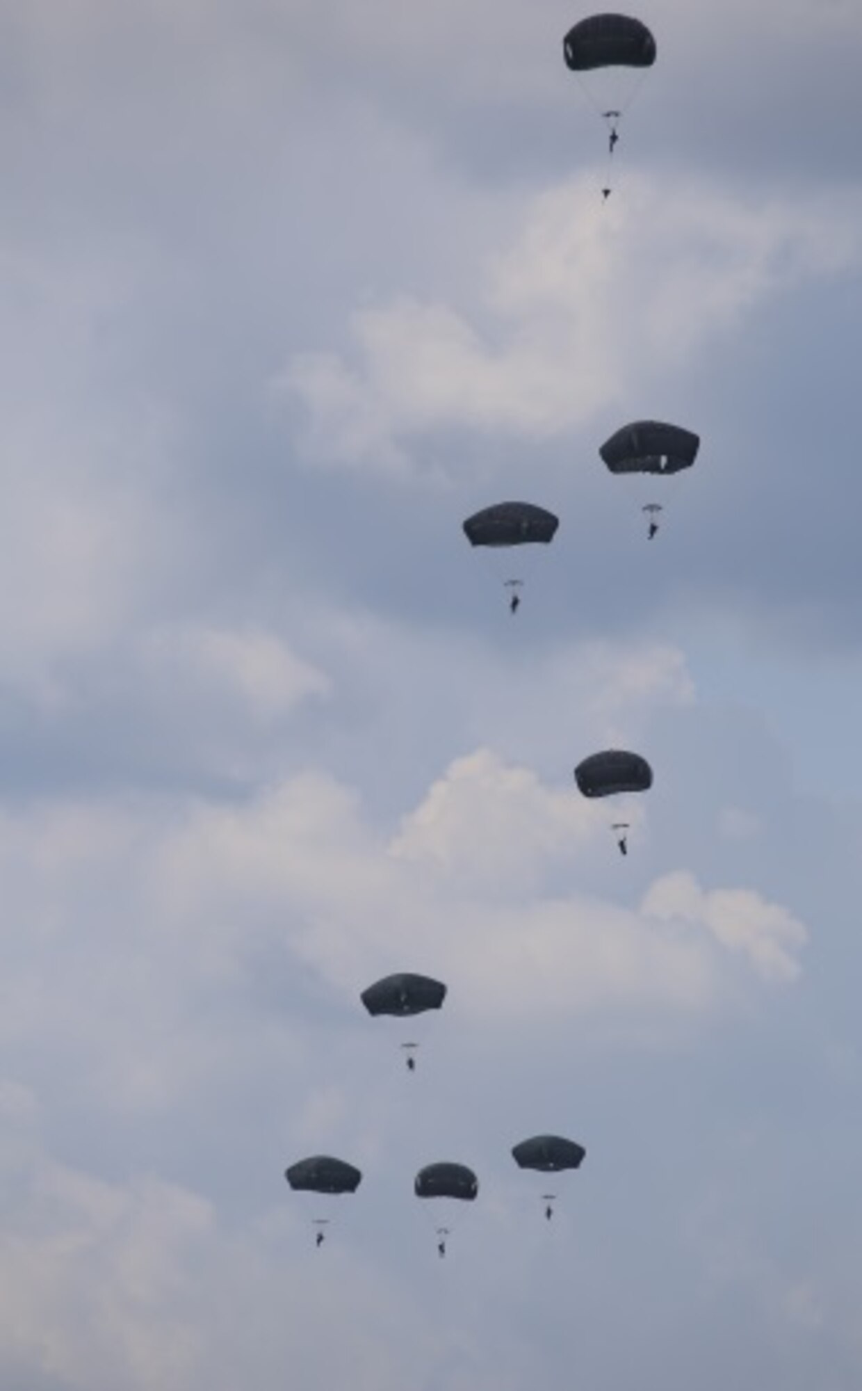 Student paratroopers descend towards earth after successfully executing jumps from a C-130H as part of the Basic Airborne Course at Fort Benning, Ga. July 13, 2015. During the final week students conduct five jumps. Two of the jumps are "combat equipment jumps," in which the jumper carries a Molle ruck with Modular Airborne Weapons Case, and a dummy weapon. Three jumps are "Hollywood," in that the jumper only wears the parachute and reserve. The last jump will culminate combining the combat equipment with a night jump giving the student a complete understanding of a night combat equipment jump. (U.S. Air Force photo/Maj. Mark Withee)