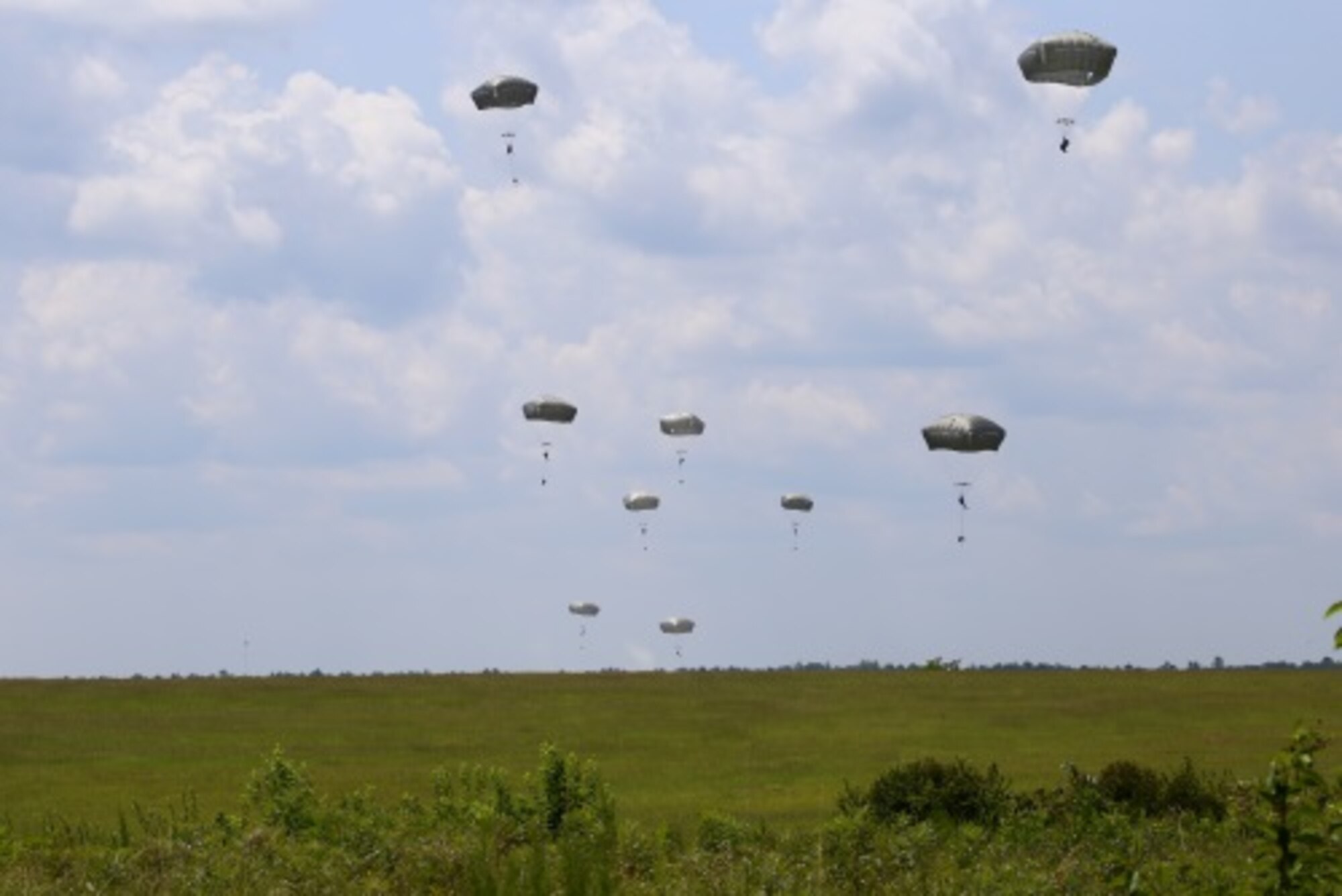 Student paratroopers descend towards Fryar Field drop zone after successfully jumping from a C-130H as part of the Basic Airborne Course at Fort Benning, Ga. July 13, 2015. (U.S. Air Force photo/Maj. Mark Withee)
