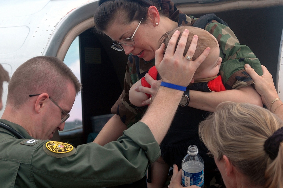 Navy Lt. Larry Anderson helps Air Force Col. Norma Allgood and her 15-month-old son out of an aircraft on Naval Air Station Jacksonville, Fla., Aug. 31, 2005. Allgood and her family, assigned to Keesler Air Force Base in Biloxi, Miss., were medically evacuated from the area after Hurricane Katrina devastated the Gulf Coast. Anderson, a flight paramedic, is assigned to the Naval Air Station Jacksonville Branch Medical Center. U.S. Navy photo by Miriam S. Gallet