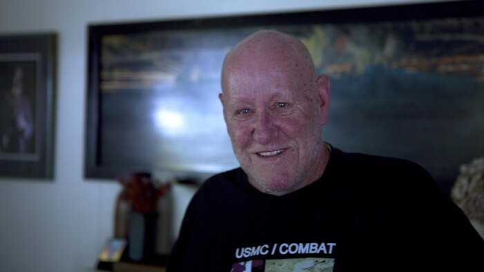 Gregory "Greg" Lake, a Marine Vietnam veteran, stands in front of a painting in his home in Calistoga, California, June 22, 2015. Lake made the painting based on a night he endured combat in Vietnam and swam across a river under fire to save the lives of his Marines. 