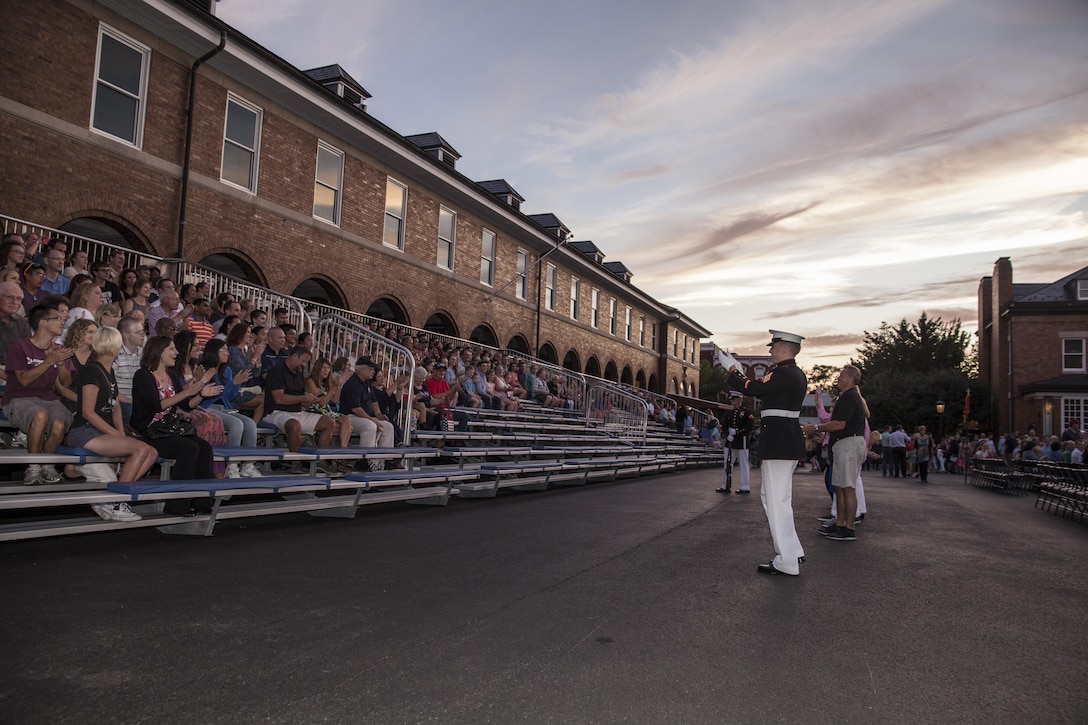 Sgt. Chase Mullens, a crowd educator with Marine Barracks Washington, D.C.,  speaks to the audience before an evening parade, Aug. 21, 2015. The guests of honor for the evening parade was The Honorable Mr. Fred Fletcher, chief of police, Chattanooga Police Department, The Honorable Mr. Earl Anthony Reavley, director of Hamilton County Emergency Services & Homeland Security, and The Honorable Mr. Andy Berke, mayor of Chattanooga, Tenn., and the hosting official was Lt. Gen. Richard P. Mills, commander of Marine Forces Reserve, and Marine Forces North. 